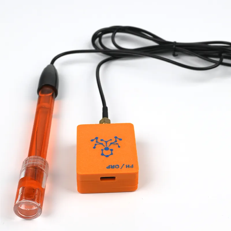 The YuzhaLink pH sensor: an orange-bodied pH electrode with its protective storage cap fitted, joined by a thin black cable to a small orange Wi-Fi acquisition module marked PH / ORP, with an SMA connector on top and a USB-C port on the front